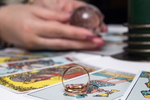 Bangkok, Thailand, March.15.20.Wedding rings are on Tarot cards. The Gypsy lays out Tarot cards and guesses for the future. Magic sessions with talking Tarot cards with heart and wedding rings