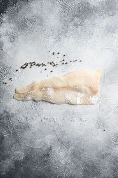 Cod fillets on a grey concrete background for the preparation of a healthy dish top view space for text.