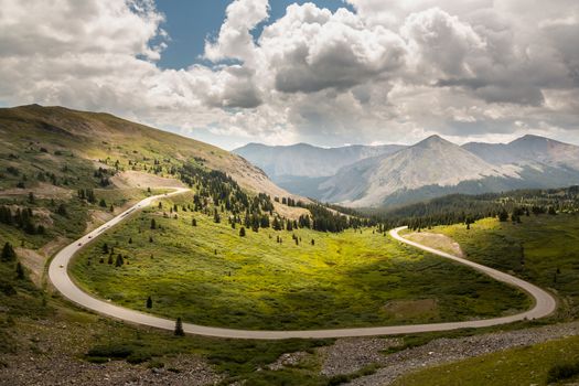 Large curving bend on road climbing to top of Cottonwood Pass in Colorado as sports cars race to summit