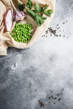 english style mushy peas organic ingredients peas mint shallot pepper and salt keto food photo over grey stone background and cloth top view vertical. Concept space for text.