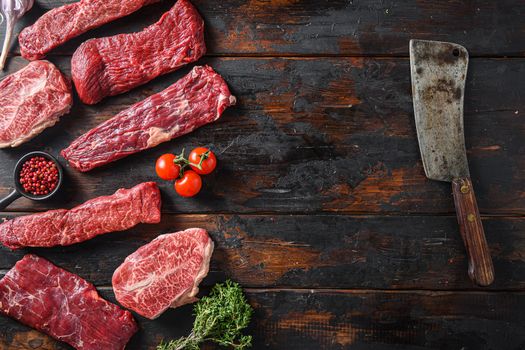 Set of flap flank Steak, machete steak or skirt cut, Top blade or flat iron beef and tri tip, triangle roast with denver cut with butcher cleaver top view over old butcher wood table. Space for text.