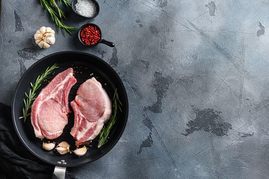 Pork steaks, fillets for grilling, baking in frying pan black skillet with herbs, spices top view flatlay space for text