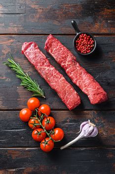 Raw denver steak or organic top blade wuth herbs top view on old wooden planks surface.