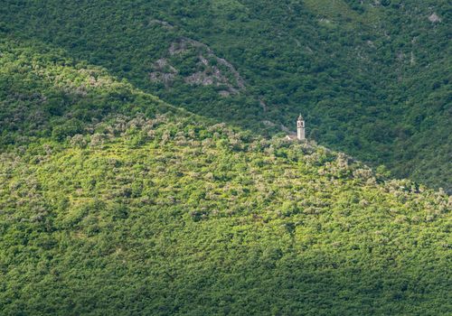Small church on hillside of coastline of Gulf of Kotor in Montenegro