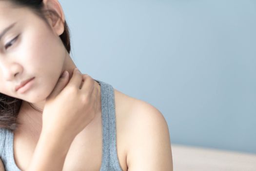Closeup woman holding neck with pain after waking up on bed, healthy care and medical concept