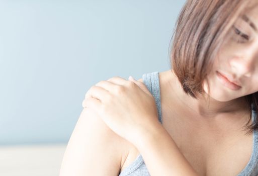 Closeup woman hand holding shoulder with pain on white background