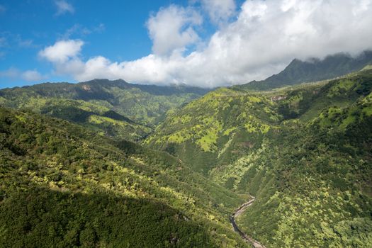 Aerial view of Manawaiopuna Falls and landscape of hawaiian island of Kauai from helicopter flight