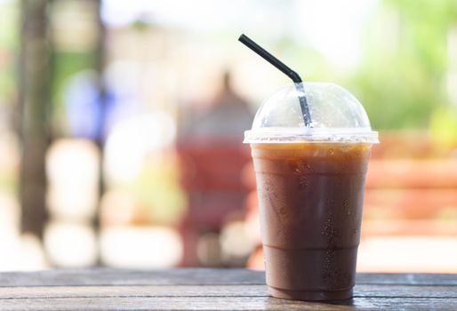 Close up glass of ice americano coffee on wood table, selective focus
