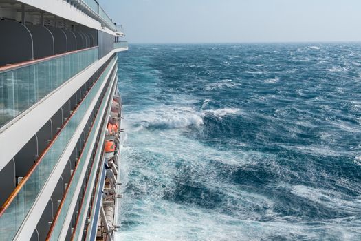 View from cabin balconies at the rough seas and waves off the side of cruise ship
