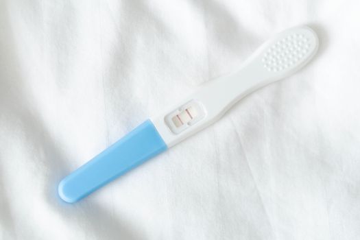 Pregnancy test on white bed background, health care and medical concept