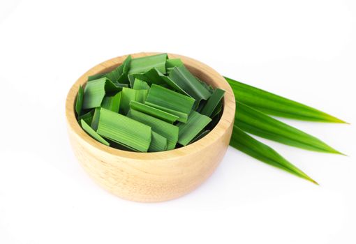 Fresh green pandan leaves with slice in wood bowl isolated on white background