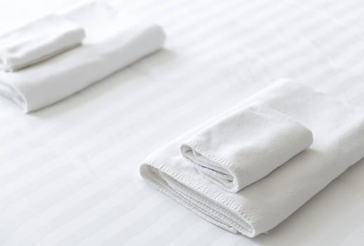 Closeup new towel on white bed