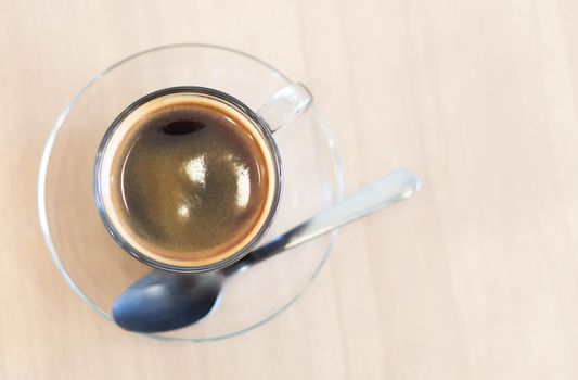 Closeup glass of hot americano coffee on wood table, selective focus, vintage tone