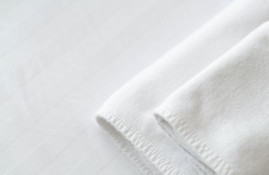 Closeup new towel on white bed with copy space