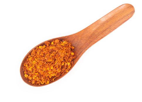 Top view red chilli power in wood spoon on white background, food ingredient