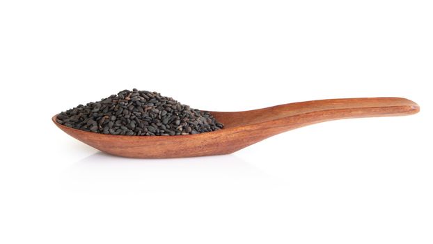 Black sesame seeds in wood spoon isolated on white background