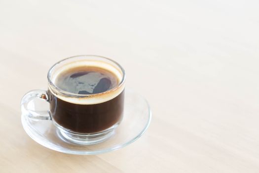 Closeup glass of hot americano coffee on wood table, selective focus, vintage tone