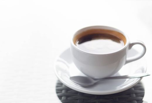 Closeup hot americano coffee on glass table with over light, selective focus