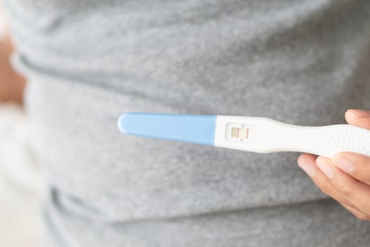 Closeup woman hand holding pregnancy test with happy moment, health care concept, selective focus