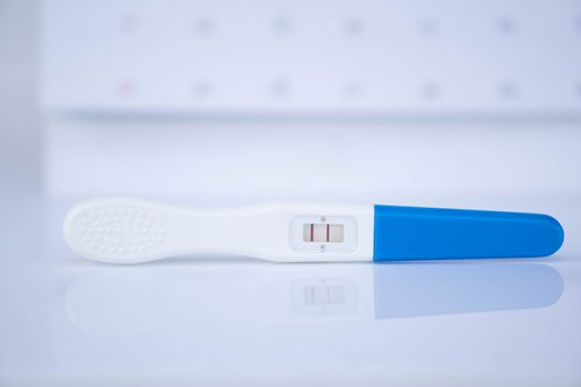 Closeup pregnancy test with calendar background, health care concept, selective focus