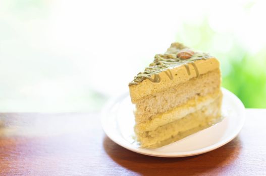 Closeup matcha green tea cake in coffee shop with nature background 