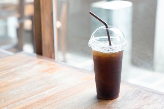 Close up ice of americano on wood table background in coffee shop