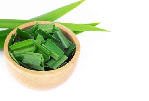 Fresh green pandan leaves with slice in wood bowl isolated on white background