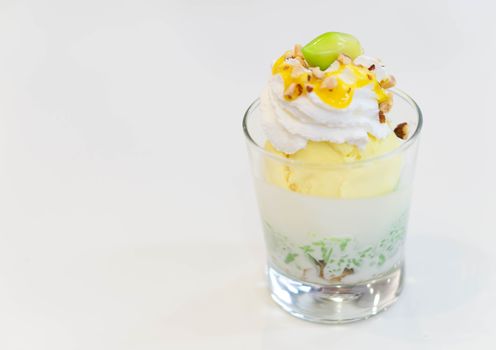 Glass of mango ice cream with wipped on white background, copy space