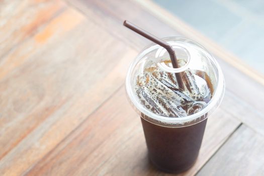 Close up ice of americano on wood table background in coffee shop