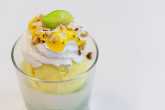 Glass of mango ice cream with wipped on white background, copy space