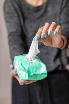 Old woman hand with turquoise nails taking the wet wipe to clean skin or surface stock photo