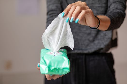 Old woman hand with turquoise nails taking the wet wipe to clean skin or surface stock photo