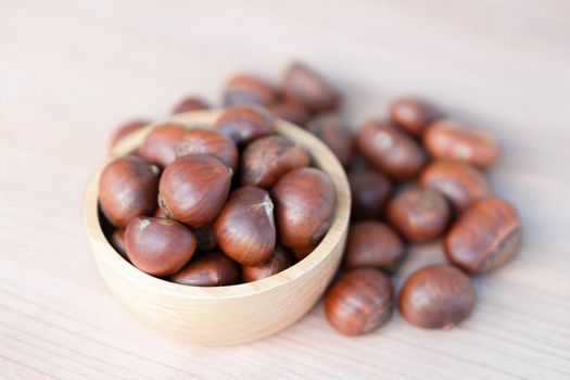 Closeup horse chestnuts in wood bowl,  healthy food concept