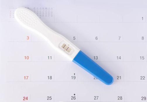 Closeup pregnancy test on calendar background, health care concept, selective focus