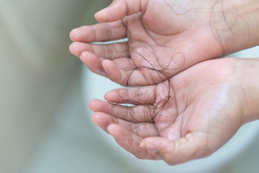 Closeup Hair loss on woman hand in the bathroom