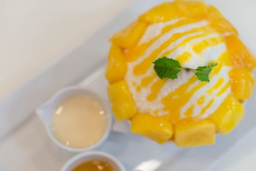 Close up mango bing su with sauces in white plate 