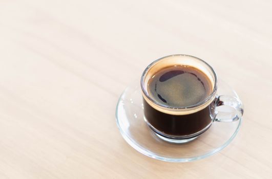 Closeup glass of hot americano coffee on wood table, selective focus, vintage tone