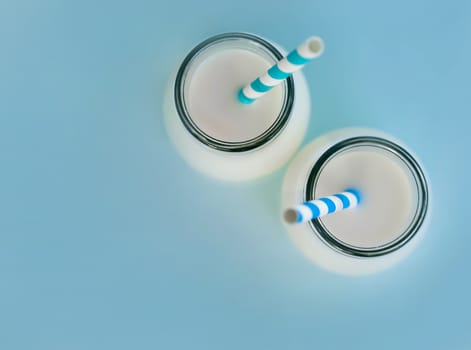 Close up topview bottle of fresh milk with straw on light blue background, food healthy concept
