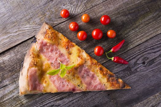 Italian food - pizza on wooden table. Cherry tomato and hot peppers