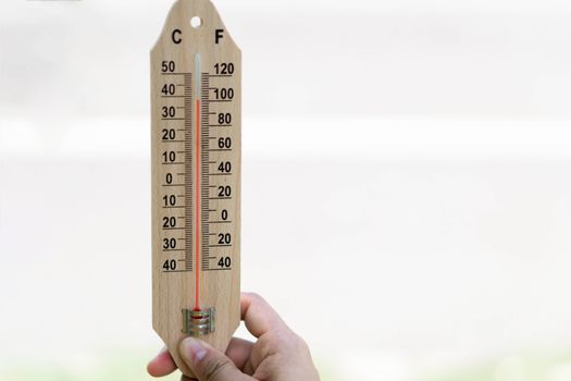 Close up hand holding thermometer with hot temperature