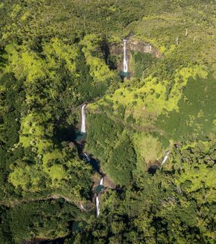 Aerial view of Manawaiopuna Falls and landscape of hawaiian island of Kauai from helicopter flight