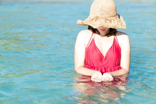 Closeup woman wearing red bikini playing sea water with happy feeling, Holiday and relax concept