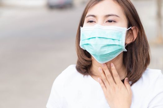 Woman wearing mask with sore throat, health care and medical concept