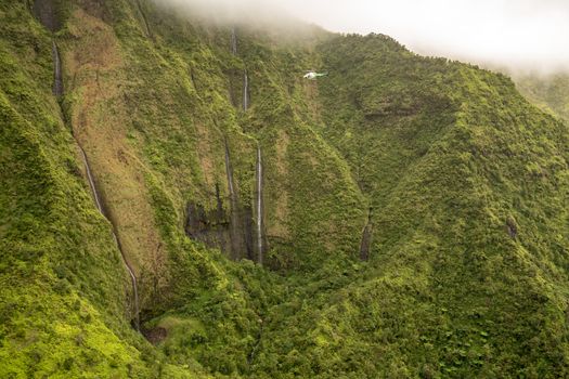 Aerial view of waterfalls in crater of Mount Waialeale on hawaiian island of Kauai from helicopter flight