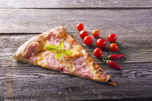 Italian food - pizza on wooden table. Cherry tomato and hot peppers