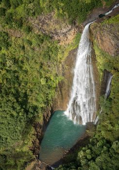 Aerial view of Manawaiopuna Falls and landscape of hawaiian island of Kauai from helicopter flight