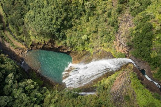 Aerial view of Manawaiopuna Falls and landscape of hawaiian island of Kauai from helicopter flight