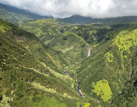 Aerial view of Manawaiopuna Falls and landscape of hawaiian island of Kauai from helicopter flight