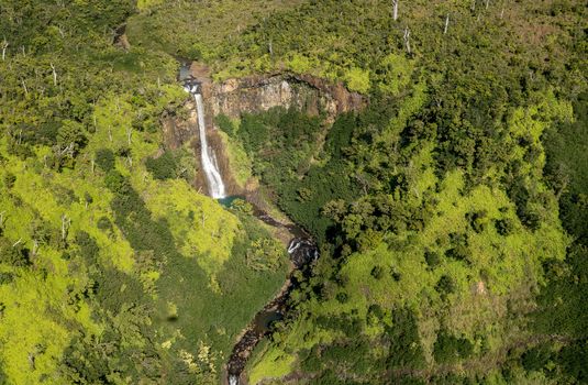 Aerial view of Manawaiopuna Falls and landscape of hawaiian island of Kauai from helicopter flight