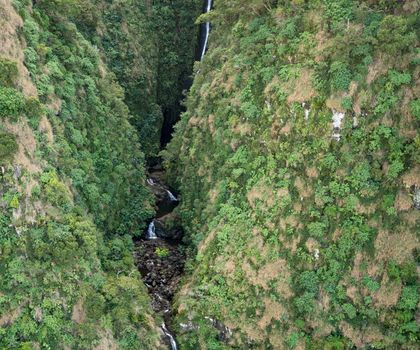 Aerial view of Hanakoa Falls on hawaiian island of Kauai from helicopter flight